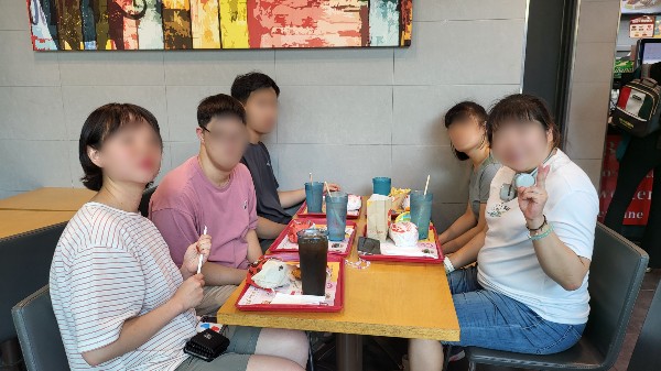 메뉴를 주문 후 테이블에서 기념사진을 찍는 이용인 모습.jpg
