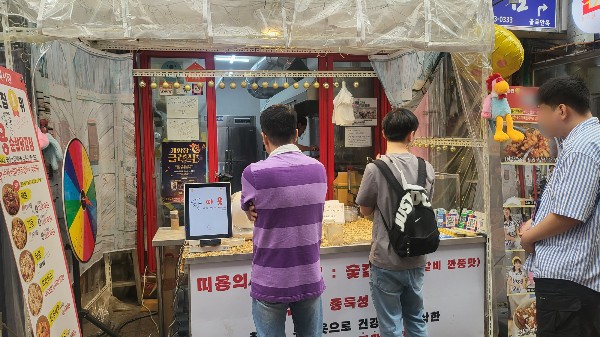 이용인들이 식당 앞에서 주문한 음식이 나오기를 기다리는 모습.jpg